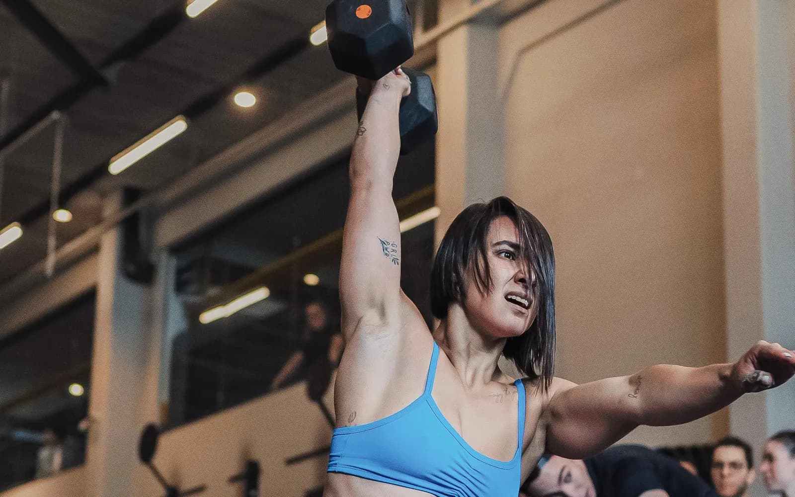 Atleta em prova de campeonato, com público e grade em volta